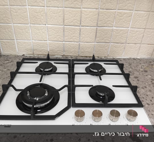כיריים גז על משטח מטבח עם כפתורים
